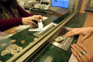 A civilian buys dollar at a currency exchange hous